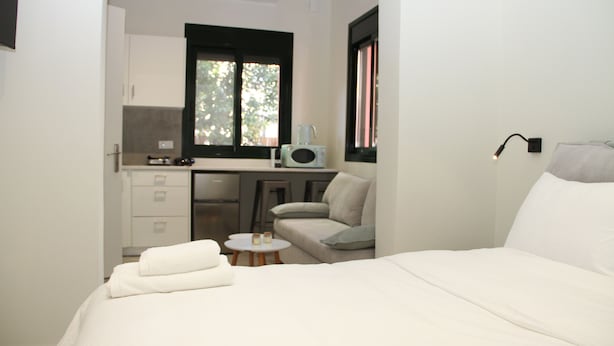 A compact room with a bed, kitchenette, and a small seating area. - Pirgos Warm Studio for 3 by MPS (Pirgos)
