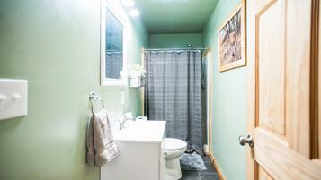 A bathroom with a white sink, a toilet, and a shower curtain.