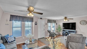 A living room with a sofa, armchair, and a TV stand. - Beautiful Lakeview Chateau With Stunning Views 3 Bedroom Home (Rutledge)