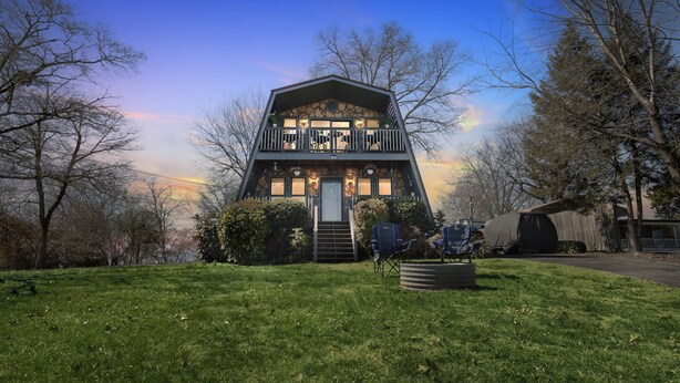 A two-story house with a balcony, surrounded by trees and a grassy lawn. - Beautiful Lakeview Chateau With Stunning Views 3 Bedroom Home (Rutledge)