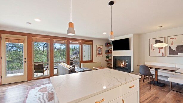 A modern kitchen with a marble countertop, wooden cabinets, and a fireplace. - Seventh Mt 1417/1418 1 Bedroom Condo (Bend)