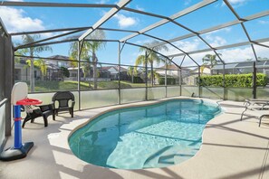 Una piscina coperta con canestri da basket, lettini prendisole e vista sul quartiere.