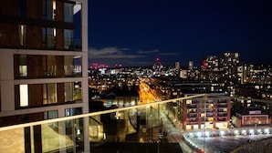 Une vue nocturne d’une ville, avec des bâtiments modernes et des rues illuminées.