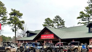 Eine Reihe von Geländewagen parkt vor einem Gebäude, an dem ein Schild mit der Aufschrift 'Cove Creek Country Store' hängt.