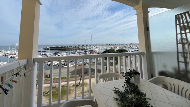 Ein Balkon mit Blick auf einen Yachthafen und das Meer.