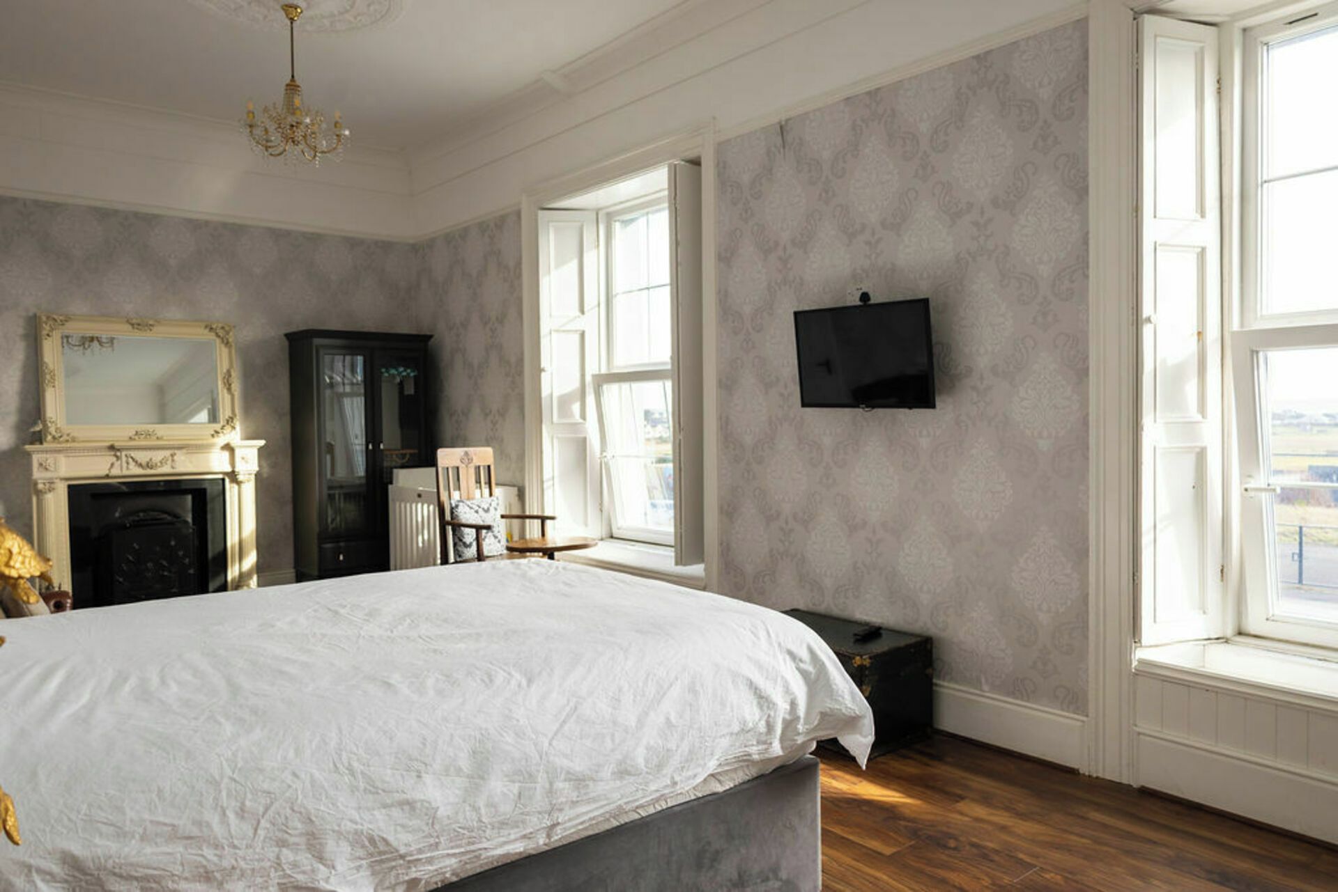 Una camera da letto con un letto grande, un camino, una televisione e ampie finestre.