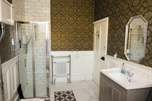 A bathroom with a shower, a toilet, a sink, and a mirror.