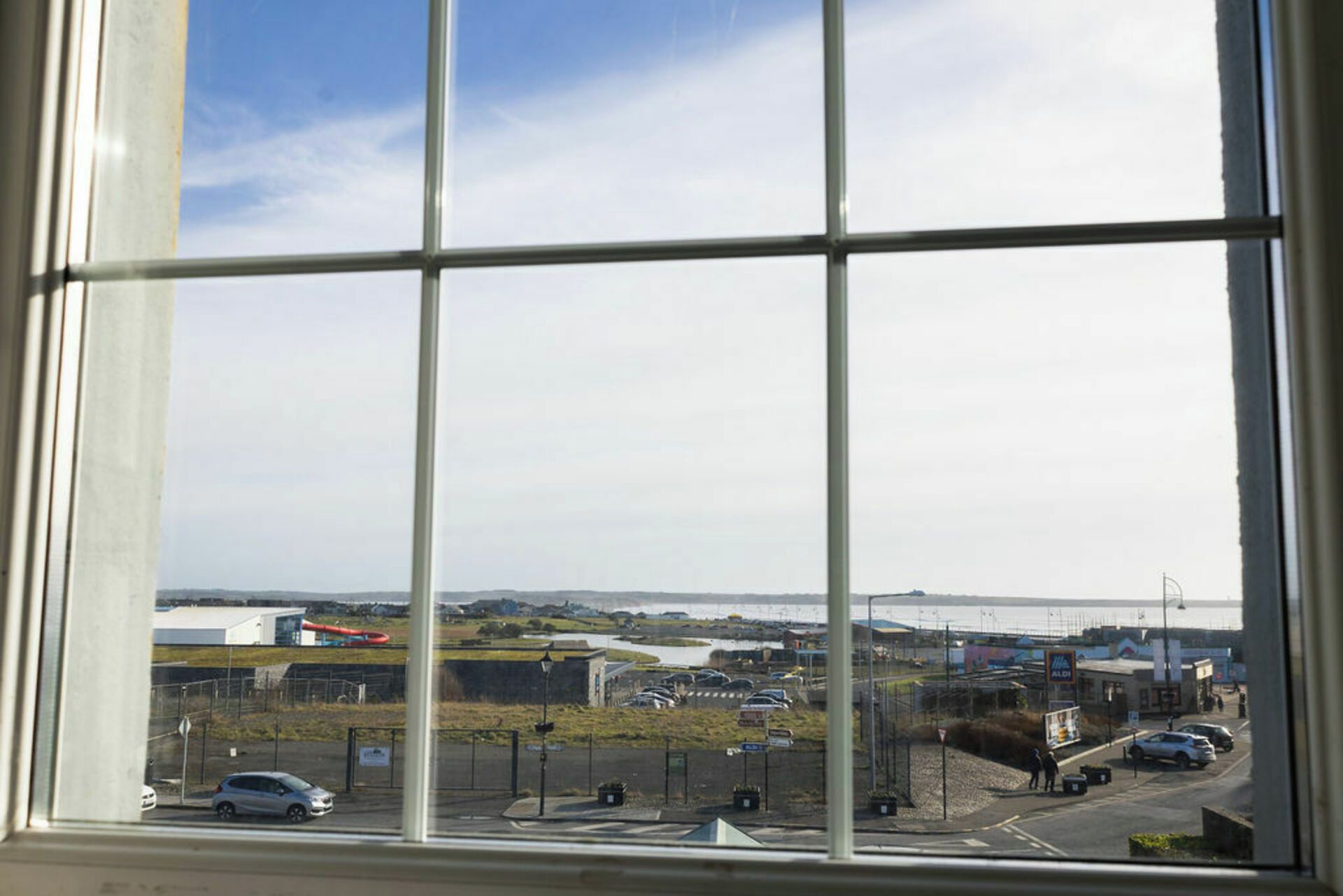 A view through a window with a clear sky and a distant landscape.