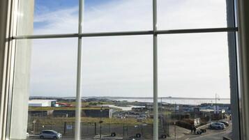 A view through a window with a clear sky and a distant landscape.