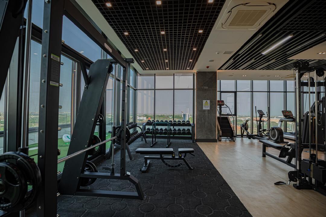 A gym with weightlifting equipment, treadmills, and exercise bikes.