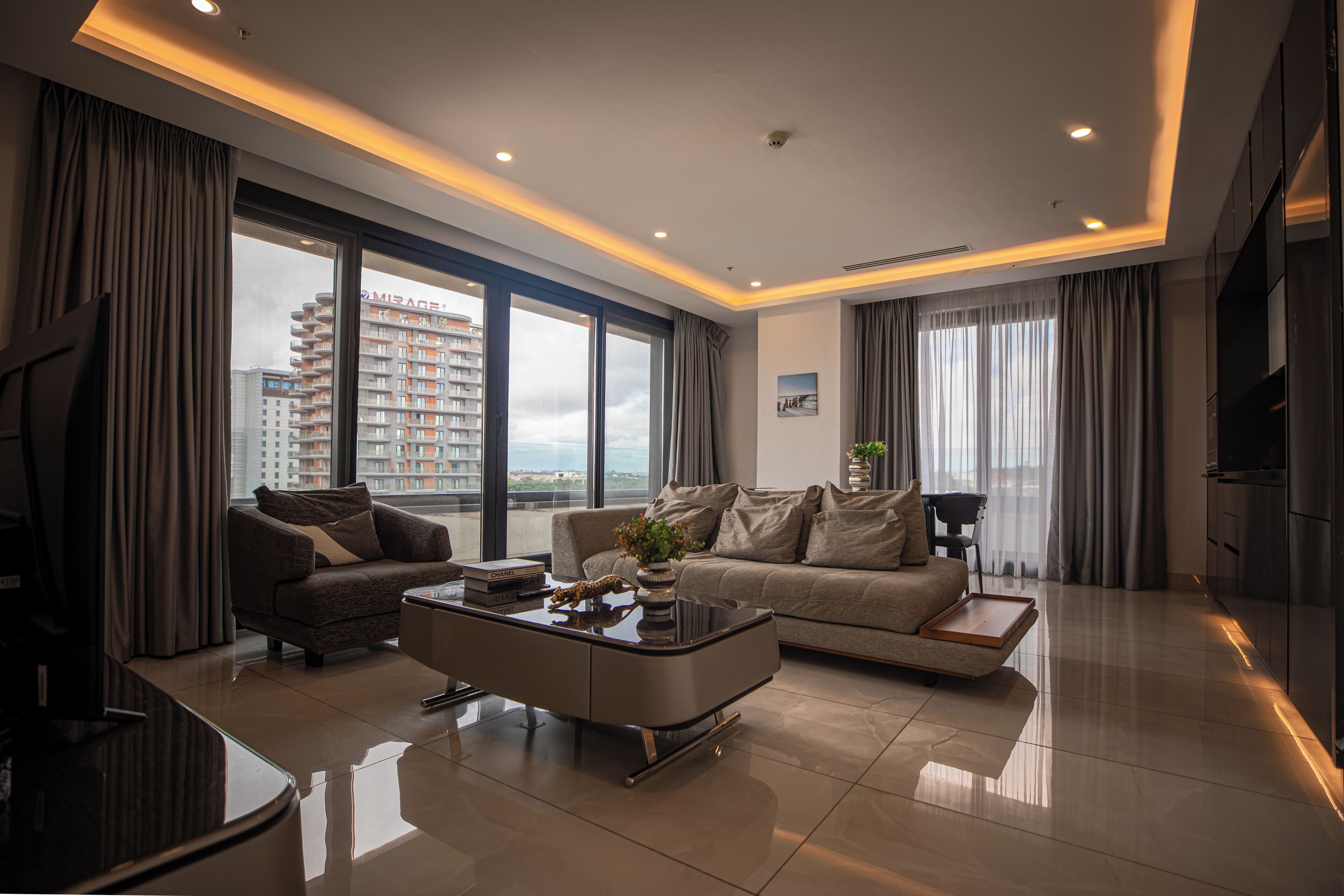 A modern living room with a sofa, coffee table, and a TV.