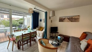 Un salon moderne comprenant un coin repas, un canapé et un téléviseur.