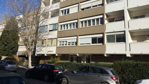 A multi-story residential building with a flat facade, multiple balconies, and a parking area with cars. - 3-room apartment with balcony and air conditioning in Balaruc-les-Bains (Balaruc-les-Bains)