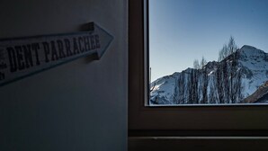 Ein Fenster mit Blick auf schneebedeckte Berge und einem Schild mit der Aufschrift "DENT PARRACHER".