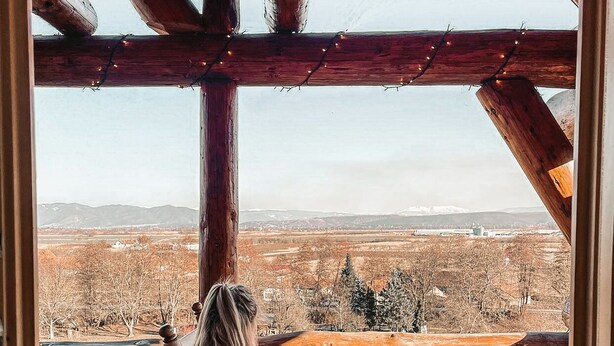 A cozy cabin with a large window overlooking a snowy landscape.