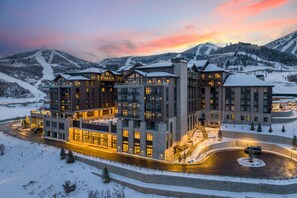 Un hotel de varios pisos con un paisaje nevado al fondo.