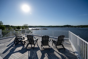 Una terrazza con poltrone Adirondack che si affaccia su un specchio d'acqua.