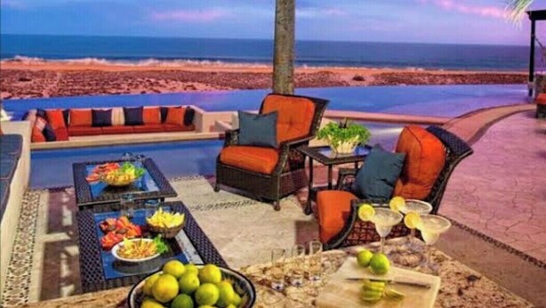 Une terrasse avec des sièges extérieurs, une piscine et une vue sur la plage et l’océan.