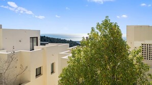 Un edificio moderno con techo plano, ventanas amplias y vista al mar.
