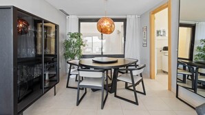 Un comedor moderno con una mesa redonda, sillas y una lámpara colgante.
