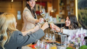 A group of people toasting with wine glasses at a table in a restaurant. - Agriturismo Pra' dell'Ort (Valdobbiadene)