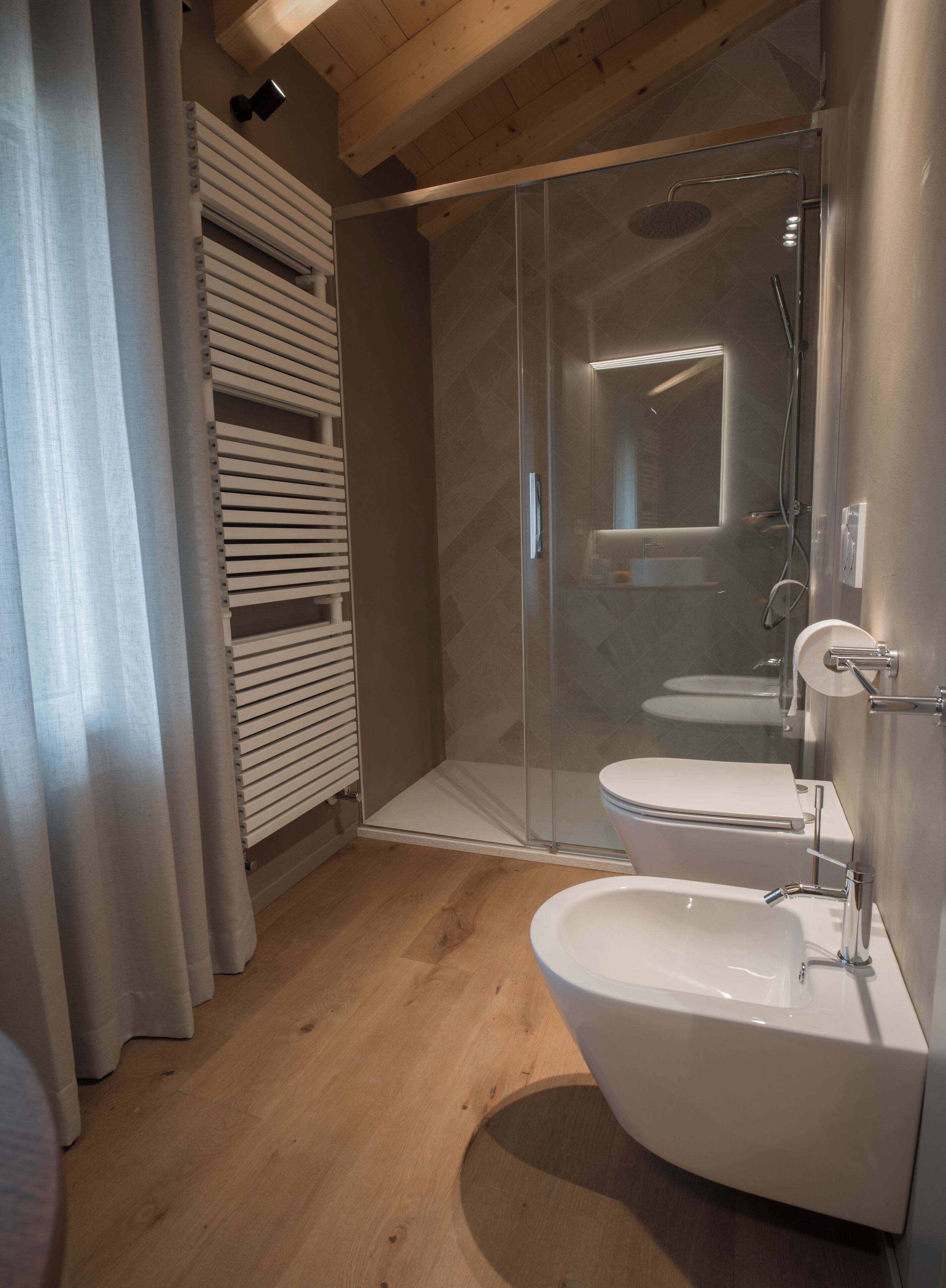 Un bagno moderno con box doccia in vetro, un water e un bidet.