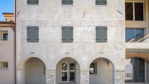 A building with a symmetrical facade, multiple windows, and three arched entrances. - Agriturismo Pra' dell'Ort (Valdobbiadene)