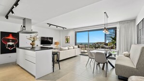 A modern living room with a sofa, dining table, and kitchen area. - RDR467 - Luxury penthouse with sea view rooftop (Estepona)