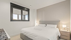 Una camera da letto moderna con un letto grande, comodini e una finestra con vista.
