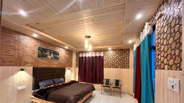 A bedroom with a wooden bed, a headboard, a wall-mounted light, and a stone wall. - Apple velley homestay shanghar  (Sainj)