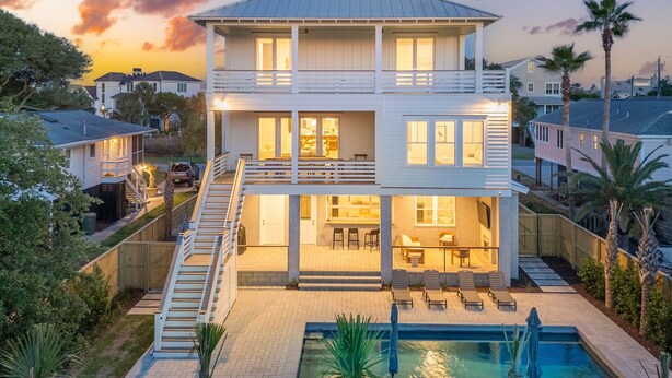 A two-story house with a balcony, a swimming pool, and a patio area. - 619 Carolina / Sleeps 12 / C Escape / Brand New Custom Home With Pool (Isle of Palms)