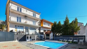 A two-story building with a swimming pool, outdoor seating, and a small barbecue area. - Apartment Dijana with private pool (Donji Prolozac)