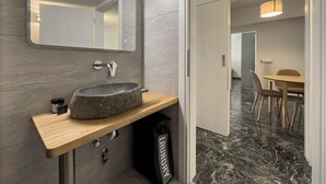 A modern bathroom with a stone sink, a mirror, and a wooden countertop. - Phaedrus Living Koukaki Verdant Marble (Athens)