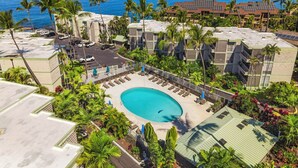 Ein Resort mit Pool, Palmen und Meerblick.