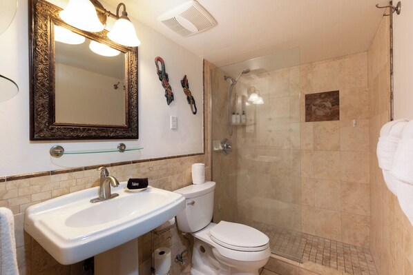 A bathroom with a sink, toilet, and shower. - Alii Villas #135: Ground Floor, Oceanfront, Remodeled, AC, Incredible Sunsets (KAILUA KONA)