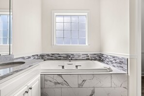 A bathroom with a freestanding bathtub, a window, and a tiled backsplash. - Lakefront, Private Pool, Walk to Beach, Water View, Golf Cart Options (Destin)