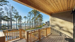 A wooden deck with a railing overlooking a beach and forest. - Seabrook Townhome | Ocean View, Hot Tub | 4BR/8 | Beach 3 Min Walk, Garage (Pacific Beach)