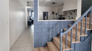 A modern interior with a staircase, a kitchen area, and a hallway. - House in the very center - 350 m from the main beach - 6 people. (FOURAS)