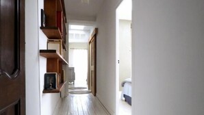 A narrow hallway with wooden flooring and a bookshelf on the left. - House in the very center - 350 m from the main beach - 6 people. (FOURAS)