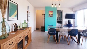 Un comedor moderno con un mueble de madera, un florero de vidrio y un mapa enmarcado en la pared.