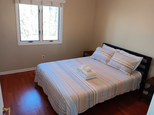 Un dormitorio con cama, ventana y puerta.