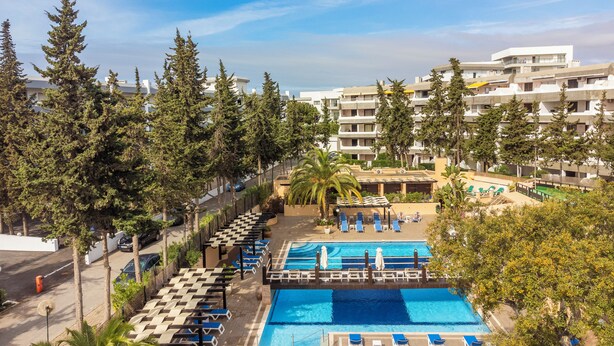 Un complexe hôtelier doté de plusieurs piscines, d’espaces de détente et offrant une vue imprenable sur de grands arbres et des bâtiments.