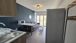 A compact kitchen with a microwave, sink, and a refrigerator.