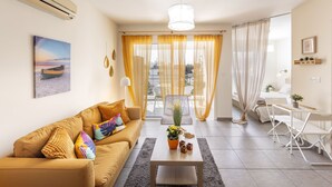 Ein modernes Wohnzimmer mit einer Couch, einem Couchtisch und einem Essbereich mit Stühlen.