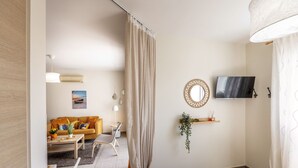 Ein modernes Wohnzimmer mit einer Couch, einem Couchtisch und einem an der Wand montierten Fernseher.