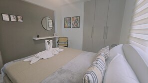 Een hotelkamer met een bed, een stoel, een garderobe en kunstwerken aan de wanden.