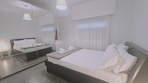 A modern hotel room with a large bed, a bedside table, a mirror, and a window with curtains. - 150 LIM -stay Limdream Apartment (Limassol)
