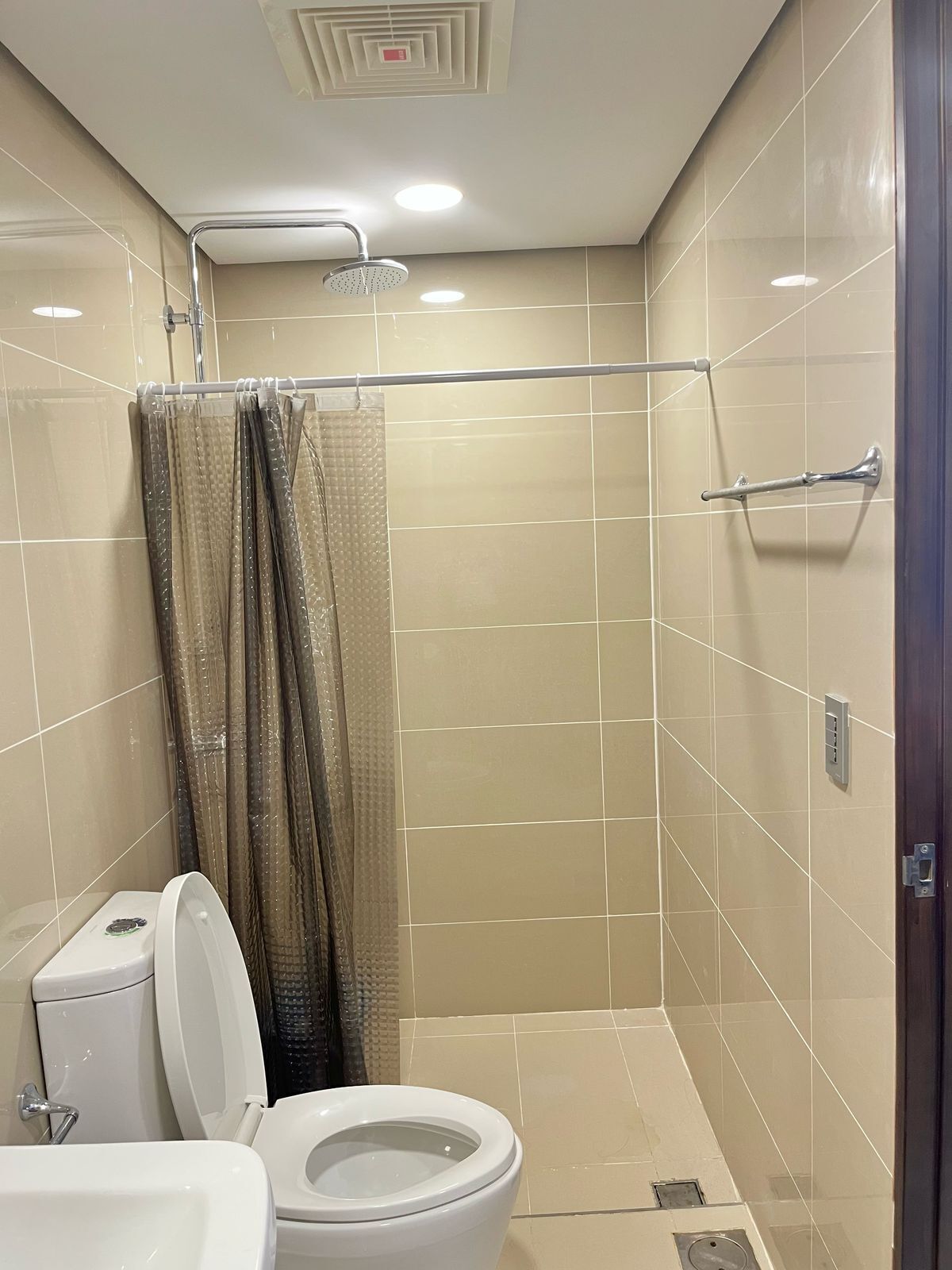 Ein Badezimmer mit Toilette, Dusche und gefliesten Wänden.