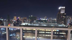 A nighttime cityscape with illuminated buildings and a bridge with a railing. - Cozy studio with Pool and fitness room in enjoyable Cebu City (Cebu City)