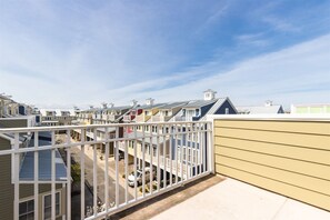 A residential area with multiple townhouses, a clear sky, and a visible street. - Sunset Island 3 Fountain Drive West (Ocean City)